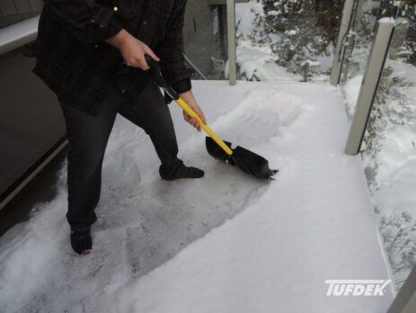 How To Winter Proof Your Deck against snow and moisture - man shovelling deck snow