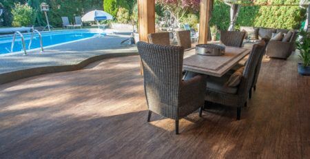 Covered deck next to a backyard pool, newly resurfaced with Tufdek outdoor waterproof vinyl decking