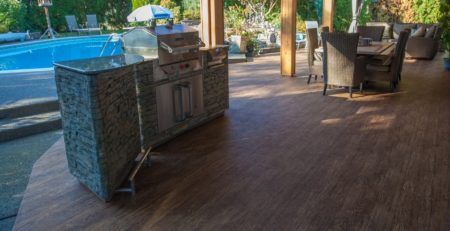 Outdoor vinyl flooring on a poolside covered deck with BBQ and deck furniture