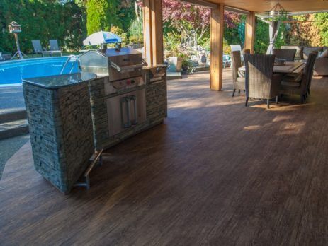 Outdoor vinyl flooring on a poolside covered deck with BBQ and deck furniture