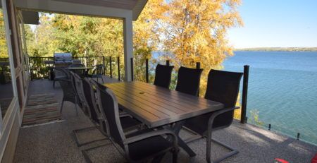 Newly finished lakefront vinyl decking with deck furniture and babecue