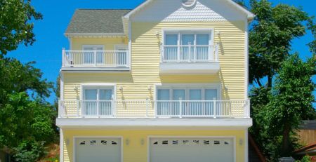 Yellow 3-story house with 3 car garage