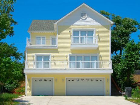 Yellow 3-story house with 3 car garage