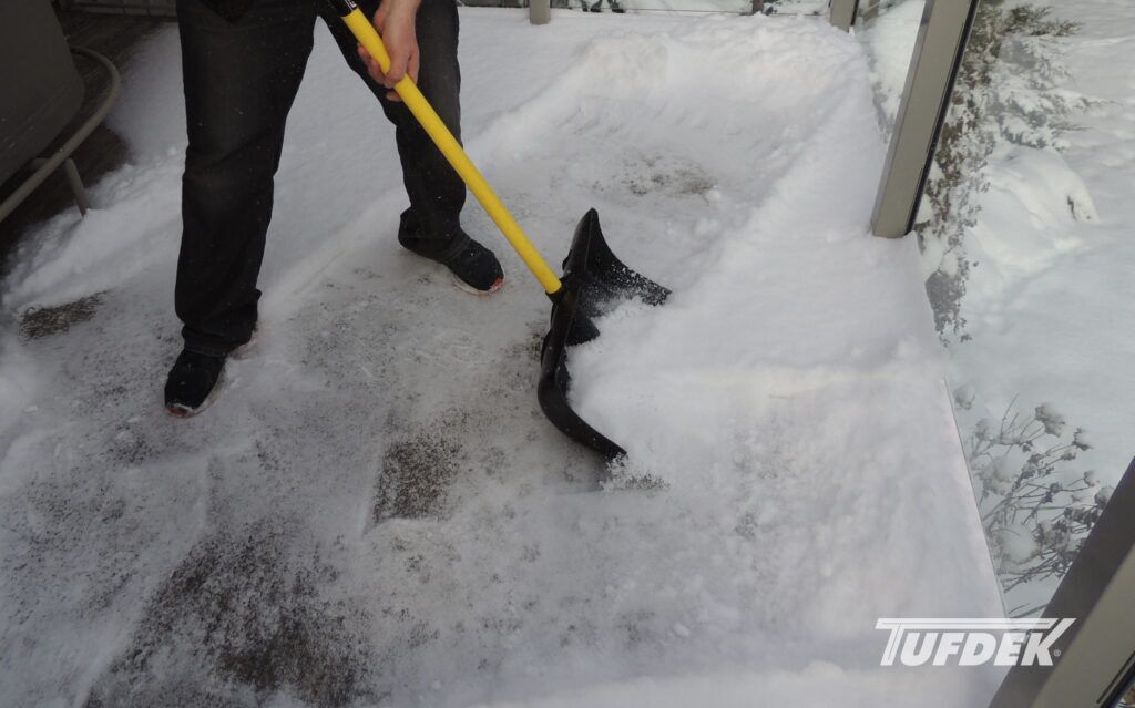 Man shovelling show off a deck