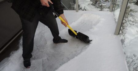 How To Winter Proof Your Deck against snow and moisture - man shovelling deck snow