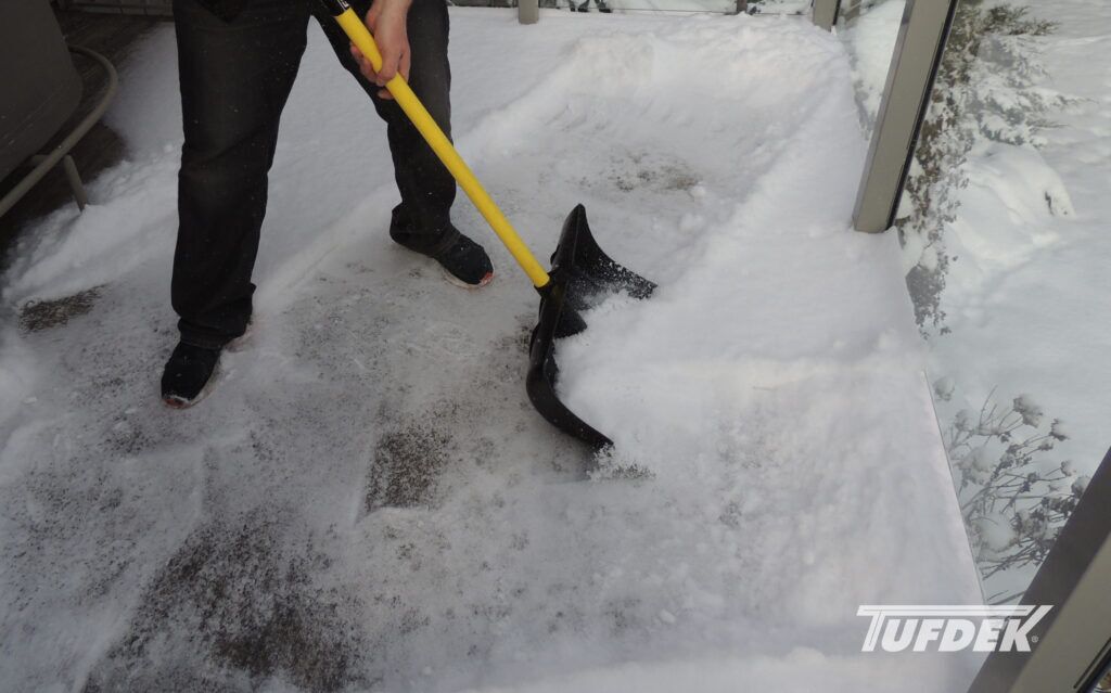 How To Winter-Proof Your Deck With Tufdek Vinyl Decking Man shovelling show off a deck