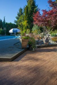 Patio next to a pool covered with outdoor waterproof vinyl decking