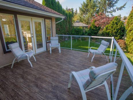 Backyard deck with 4 deck chairs - newly waterproofed with outdoor vinyl deck flooring