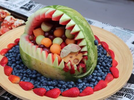 Pumkin on a fruit platter carved like an open shark's mouth