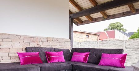 Dark purple deck furniture with neon bright purple pillows