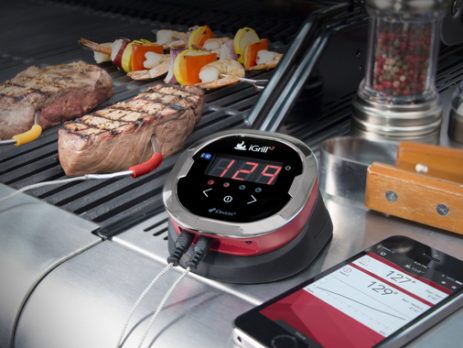 Grill timer, and smart phone next to meat on a BBQ