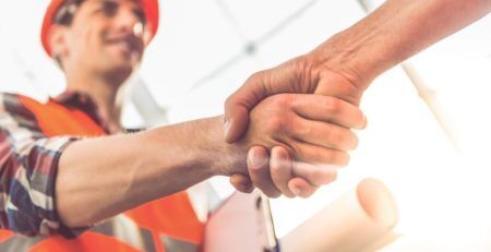 Construction worker in hard hat shaking hands with someone