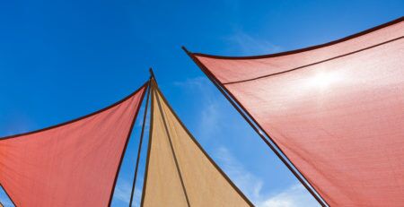 IMAGE OF COLOURFUL DECK SUN SHADES AGAINST A BLUE SKY