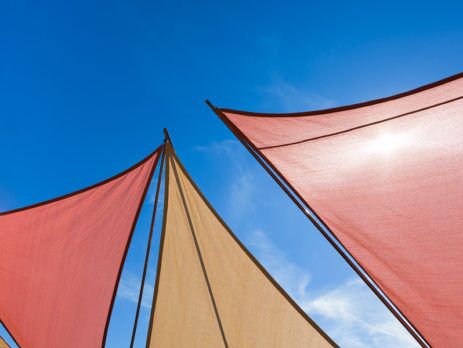 IMAGE OF COLOURFUL DECK SUN SHADES AGAINST A BLUE SKY