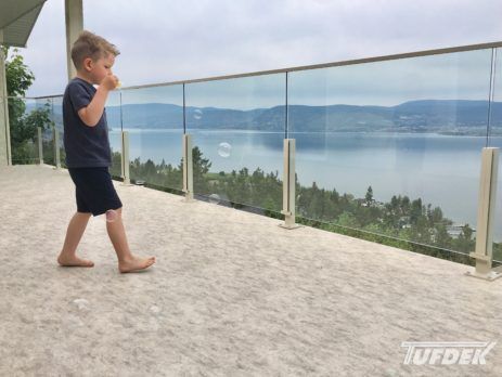 Barefoot child blowing bubbles on newly installed balcony vinyl flooring