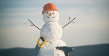 Snowman with construction hat, saw and electric drill