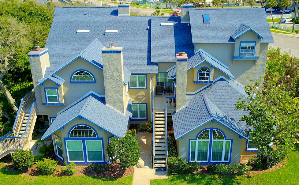 Photo of a newer home with two sets of stairs leading up to 2 different sundecks.