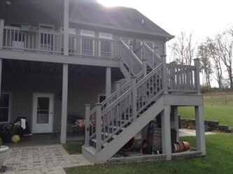 Large sundeck with stairs to the backyard and living space under the deck.